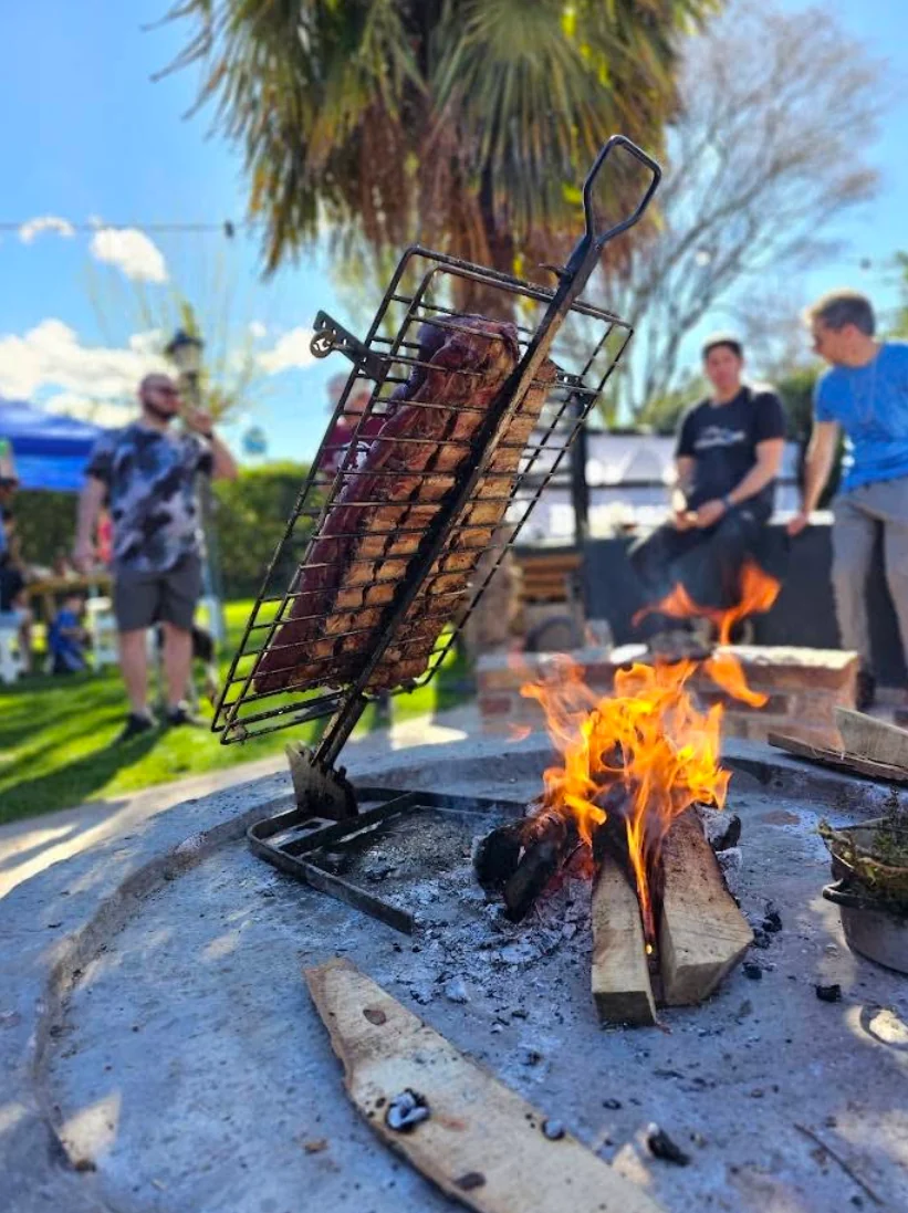 Costillar cocinándose al fuego en el asador